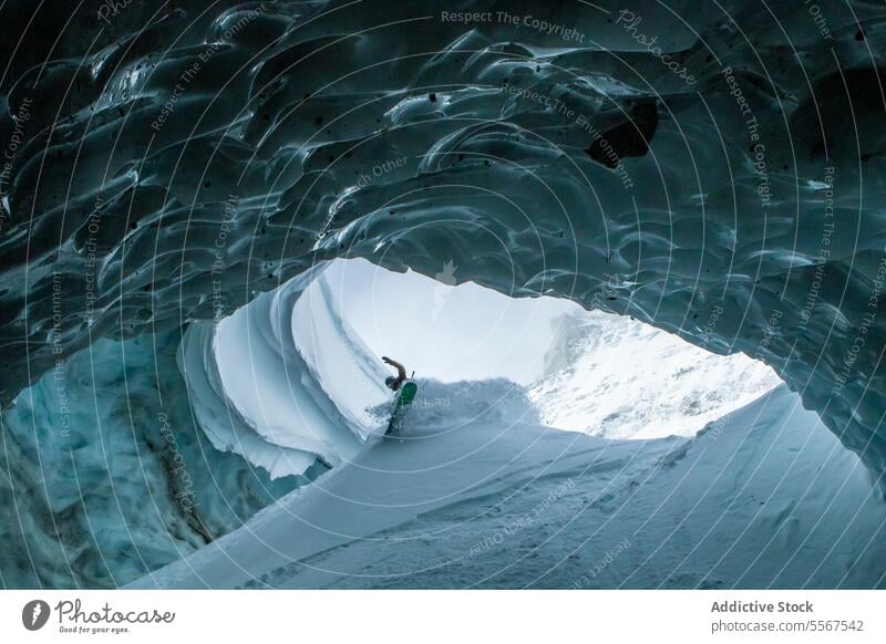 Skifahrer mit Skistöcken erkundet Höhle auf Schneeberg unkenntlich Mast laufen verschneite Berge u. Gebirge erkundend Urlaub Erkundung Person wandern Winter