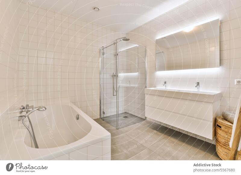 Stilvolles Badezimmer mit Duschkabine und Badewanne Dusche Kabine Spiegel Waschbecken weiß Fliesen u. Kacheln Wand modern beleuchtet Wasserhahn Waschtisch