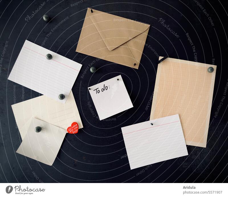 Verschiedene Zettel und ein Briefumschlag an einer schwarzen Magnetwand Memo Msgnetwand Info Papier Information Notizen leer weiß Mitteilung Post schreiben
