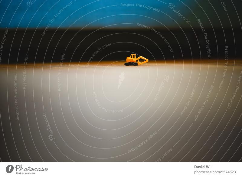 ein minni Minnibagger Minibagger Kinderspielzeug Spielzeug Baumaschine klein winzig Fußboden Kinderzimmer Spielen Kindheit Bagger aufgeräumt
