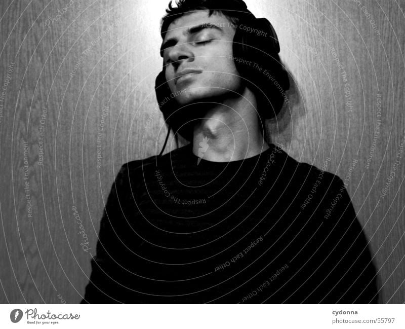 Menschenskind XII Mann Porträt Stil Wand Holz Hand Körperhaltung Pullover Musik hören Kopfhörer Licht Maserung Gesicht Gesichtsausdruck Schwarzweißfoto