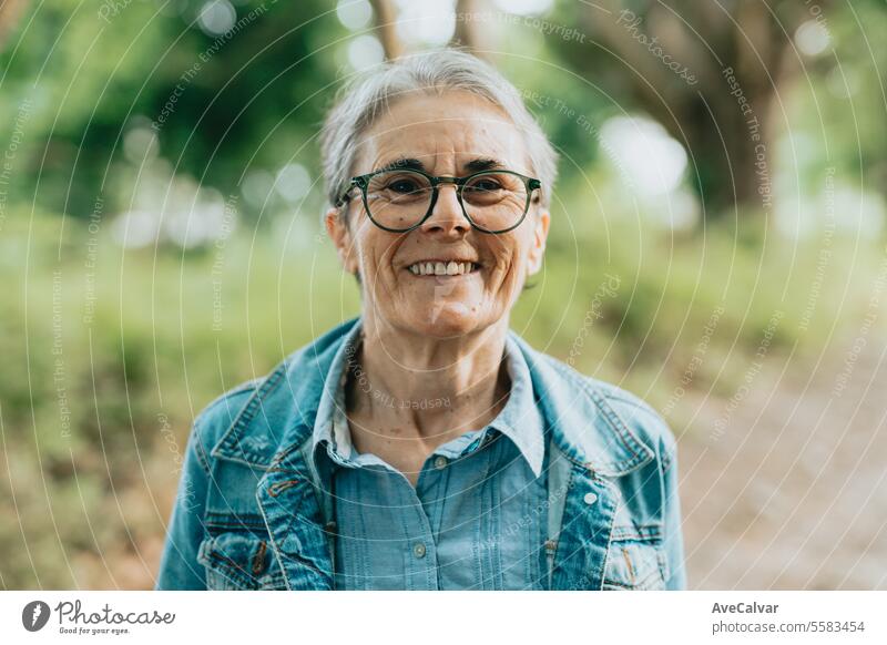 Porträt einer älteren Dame, die die Natur im Wald genießt und bei einem Spaziergang frische Luft außerhalb der Stadt atmet mental Ruhestand Glück alt Senior