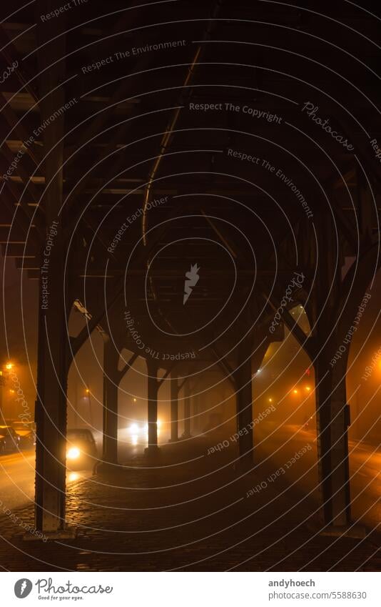 Unter einer Brücke im Nebel mit Autos auf beiden Seiten der Straße allein Asphalt schwarz PKW Großstadt kalt Textfreiraum dunkel Dunkelheit Europa neblig