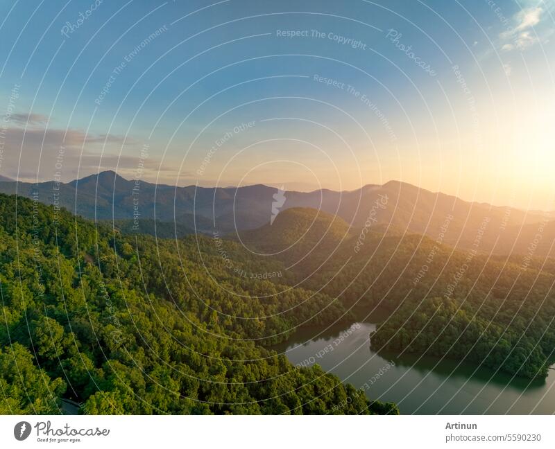 Schöne Landschaft von grünen Bergen und See am Morgen mit Sonnenaufgang Himmel. Naturlandschaft. Watershed Wald. Wasser und Wald Nachhaltigkeitskonzept. Luftaufnahme von Berg mit grünen Bäumen.