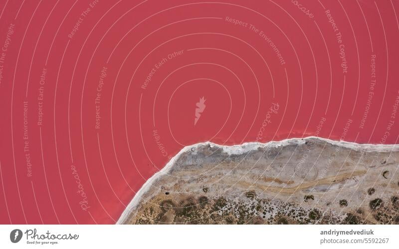 Überfliegen eines rosa Salzsees. Salzproduktionsanlagen salzhaltig Luftaufnahme Single Hintergrund See Salzkristalle Strand farbenfroher Hintergrund schön Küste
