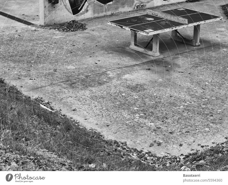 Tischtennisplatte aus Beton auf Betonplatz vor Betonwand, Schwarzweissaufnahme Stadt Großstadt Pingpong Menschenleer grau trist Schwarzweißfoto Außenaufnahme