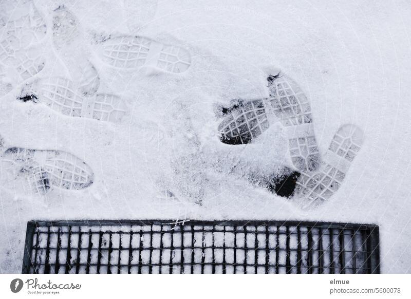 Schuhabdrücke von Arbeitsschuhen im Schnee vor einem Gitterrost Schuhabdruck Abstreifrost Winter Schneedecke Arbeitsalltag Fußspuren abtreten Blog Spur Abdruck