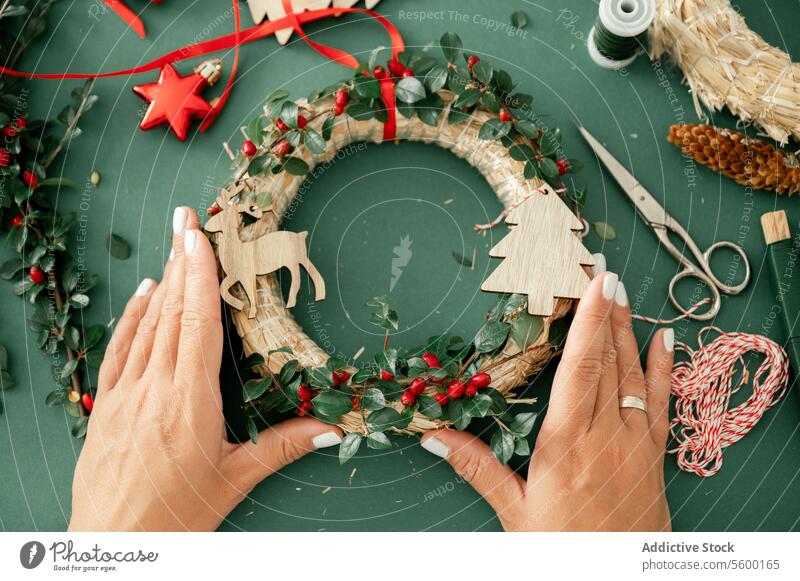 Crop Hand von unerkennbaren Frau mit dekorativen Weihnachtsschmuck Weihnachten Totenkranz Person Dekoration & Verzierung Bändchen Neujahr Tradition festlich rot