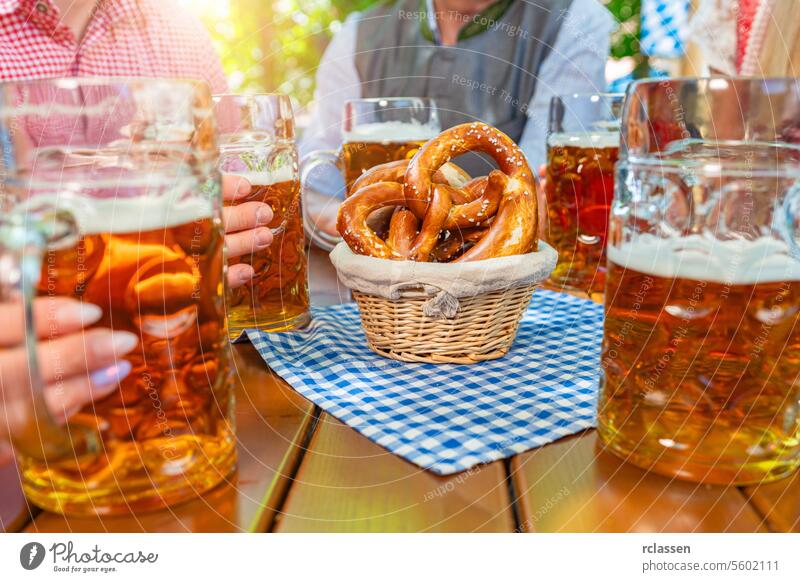 Gruppe glücklicher Freunde trinkt Bierkrug mit Brezen auf dem Oktoberfest in Bayern brezen Deutsch bayerisch Bar Feier jubelt Mann Dirndl Lagerbier Treffpunkt