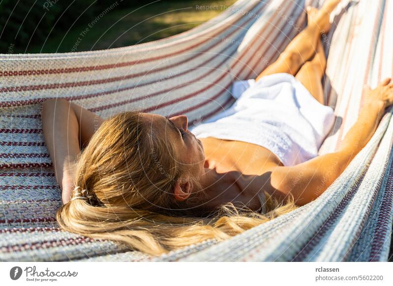 Junge Frau entspannt sich in einer Hängematte im Freien in einem Kurort Hotel Finnisch Sauna Handtuch Spa sich[Akk] entspannen thermisch Bademantel Schönheit