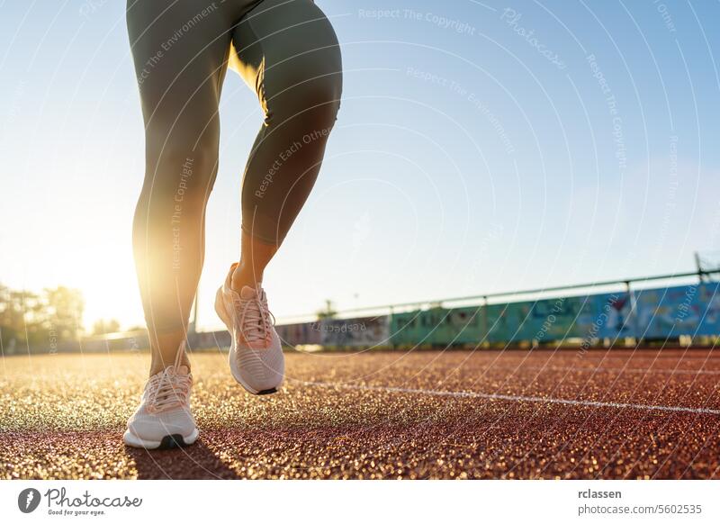 Nahaufnahme der Beine eines Läufers, der bei Sonnenaufgang auf einer Bahn zu laufen beginnt Läuferbeine Laufbahn Joggen Fitness Übung Gesunder Lebensstil