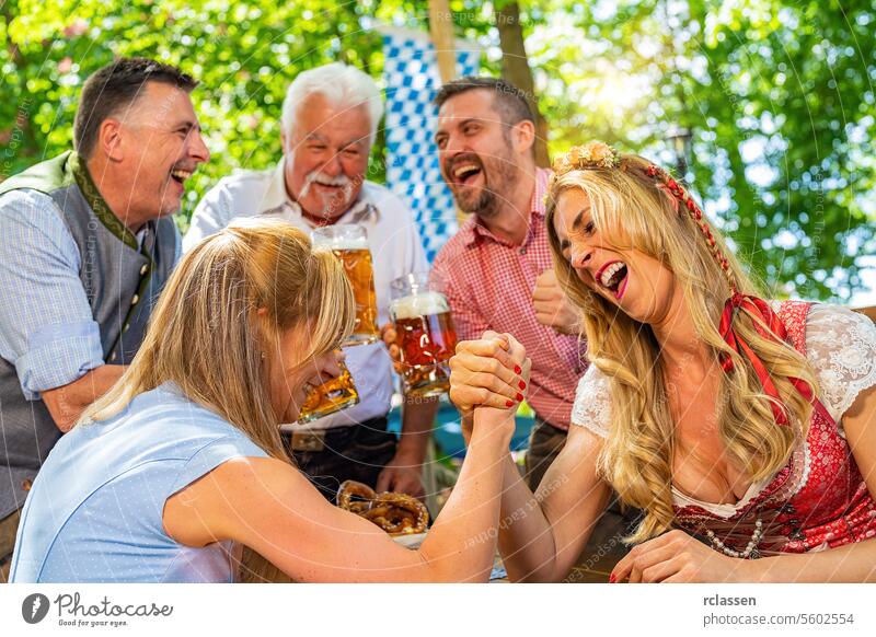Bayerische Freunde üben sich in der hohen Kunst des Armdrückens in einem Biergarten Glücksspiel anfeuern Brezeln Spiel Frau Großvater Senior Fahne