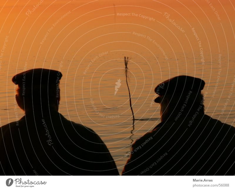Männer im Sonnenuntergang Mann Meer See Abenddämmerung ruhig Schatten organge Wasser