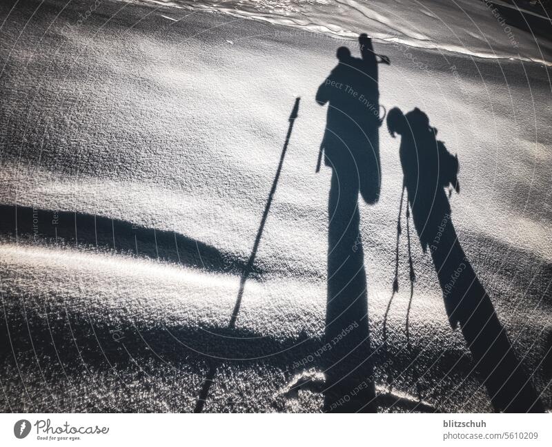 Schatten von Vater und Sohn auf einer Tour mit Schneeschuhen und Snowboard Snowboarder Winter Sport Snowboarding Wintersport Hiken Schneewandern Touren