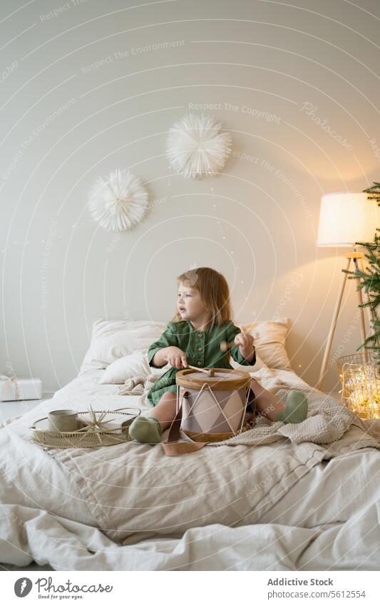 Kleinkind genießt Trommelspiel in einem dekorativen Raum Kind spielen Schlafzimmer gemütlich Warmes Licht festlich Dekoration & Verzierung Spielzeit Bett