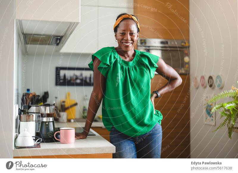 Porträt einer lächelnden reifen Frau, die in ihrer Küche steht Menschen Freude schwarz natürlich attraktiv schwarze Frau Fröhlichkeit Glück echte Menschen