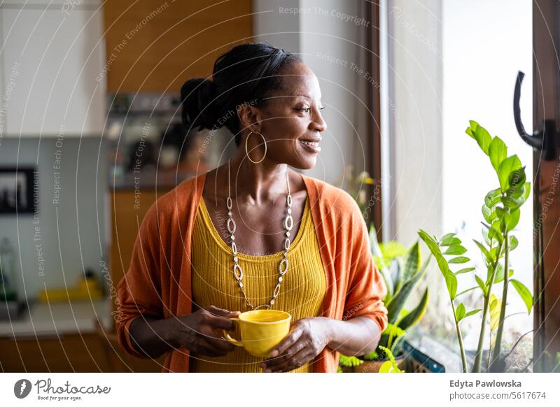 Porträt einer lächelnden reifen Frau, die in ihrer Wohnung steht Menschen Freude schwarz natürlich attraktiv schwarze Frau Fröhlichkeit Glück echte Menschen