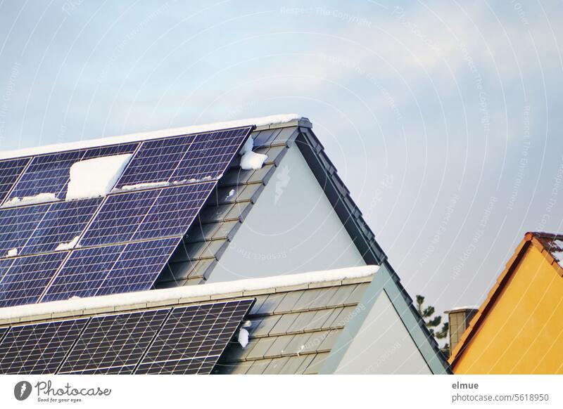 Photovoltaikanlagen auf zwei Satteldächern mit Schneeresten Fotovoltaik Winter Satteldach Giebel Erneuerbare Energie Energiewende Solarenergie Sonnenenergie