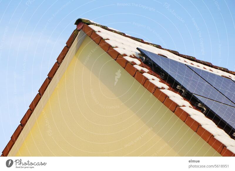 Module einer Photovoltaikanlage auf einem Satteldach mit Schneeresten Fotovoltaik Winter Giebel Erneuerbare Energie Energiewende Solarenergie Sonnenenergie