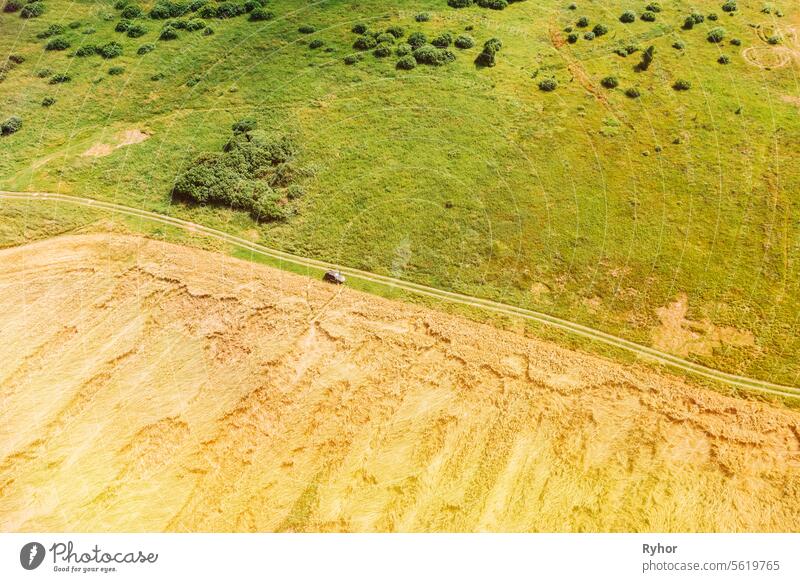 Luftaufnahme von Auto SUV geparkt in der Nähe von Countryside Road im Sommer Feld ländliche Landschaft. Gelbe Weizenfeld im Sommer Saison Antenne