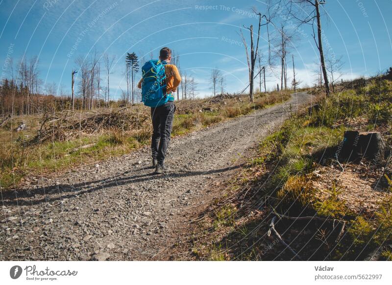 Abenteurer und Reisender mit einem blauen Rucksack beim Wandern in den Beskiden, Tschechische Republik. Wanderweg. Genießen Sie den Erfolg der magischen Natur