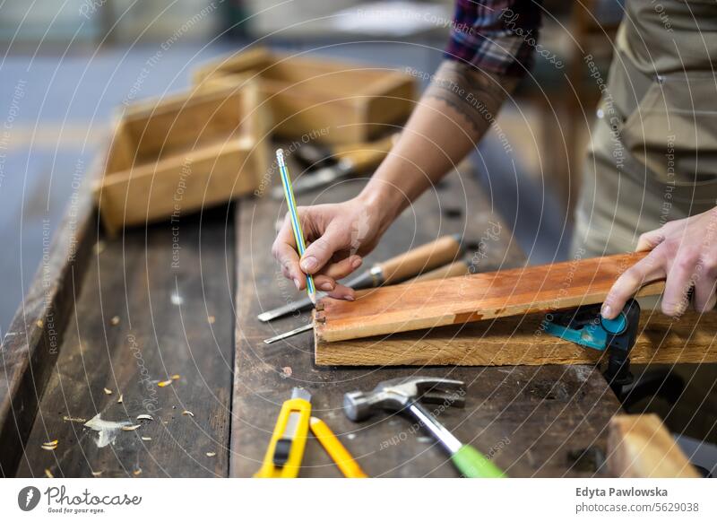 Schreinerin bei der Arbeit in ihrer Werkstatt Möbel Zimmerer wiederherstellend Schreinerei Holz Stuhl Gebäude Herstellung Handwerk Renovierung reparierend