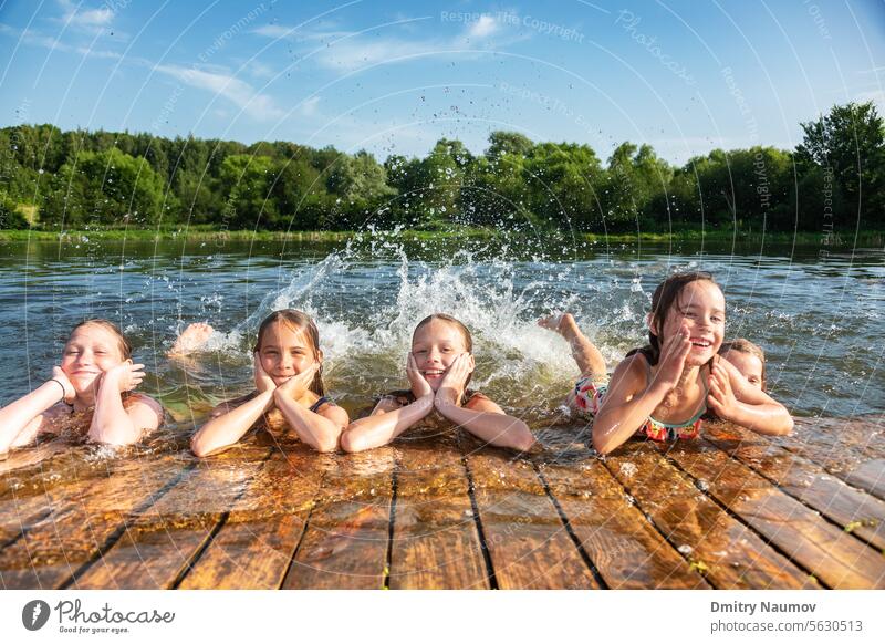 Glückliche kleine Mädchen, die in den Sommerferien in einem See spielen und Wasser spritzen Aktivität sorgenfrei Kind Kindheit Kinder Schiffsdeck Emotion
