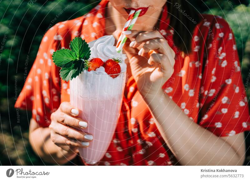 Hübsche Frau trinkt Erdbeer-Milchshake-Cocktail mit Strohhalm, Natur-Hintergrund schön Getränk Frühstück hell heiter lecker Dessert Diät trinken Essen