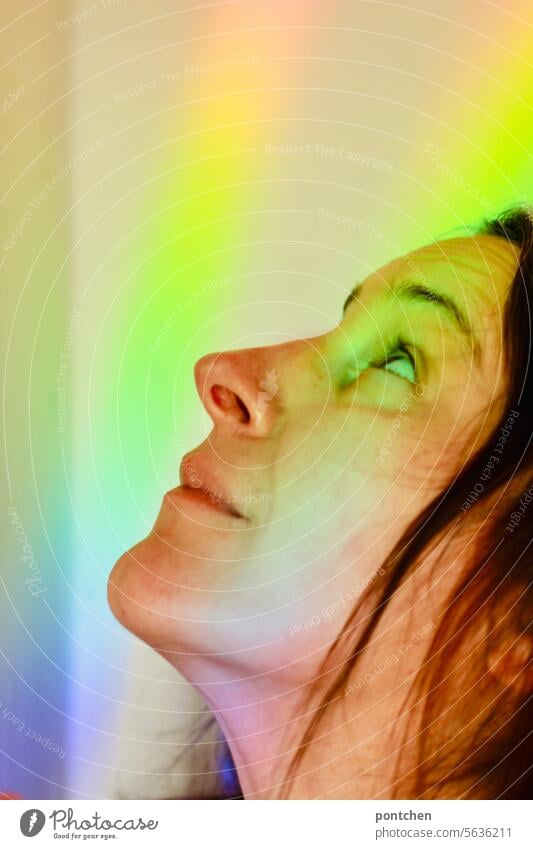 grelles, farbiges licht im gesicht einer frau. lichtstrahl regenbogen hoffnung freude glück Licht toleranz mehrfarbig Lichtbrechung Spektralfarbe