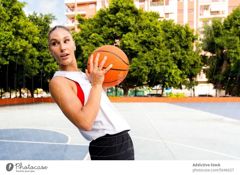 Sportlerin spielt Basketball und schaut auf dem Platz weg Ball Spieler spielen Training Sportpark üben Vitalität Frau Spielplatz Großstadt Sportbekleidung