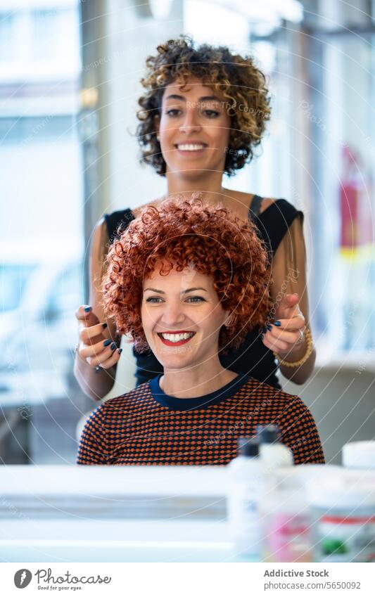 Fröhliche Frau bewundert ihre neue Frisur beim Friseur lockig rote Haare Friseursalon Lächeln Spiegel Schönheit Salon Stylist Glück Klient Kunde