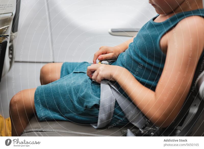 Anschnallen eines Kindes im Flugzeug Sicherheitsgurt Befestigung Hände Nahaufnahme reisen sicheres Schnalle Passagier Sitzgelegenheit Vorbereitung Reise