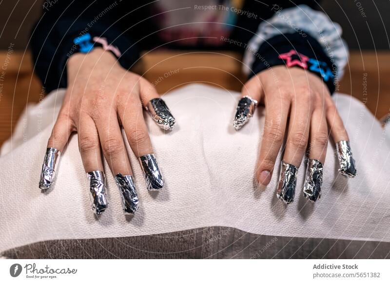 Abgeschnittene weibliche Hände beim Entfernen von Gel-Nagellack mit Folie im Kosmetikstudio Maniküre Verfahren Frau nageln Leckerbissen polnisch Salon Schönheit
