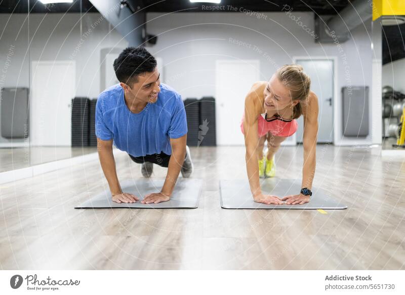 Fitnesspartner bei Liegestützen in einem modernen Fitnessstudio Übung Glück Training Gesundheit Sport aktiv Partnerschaft Herausforderung Stärke Mann Frau