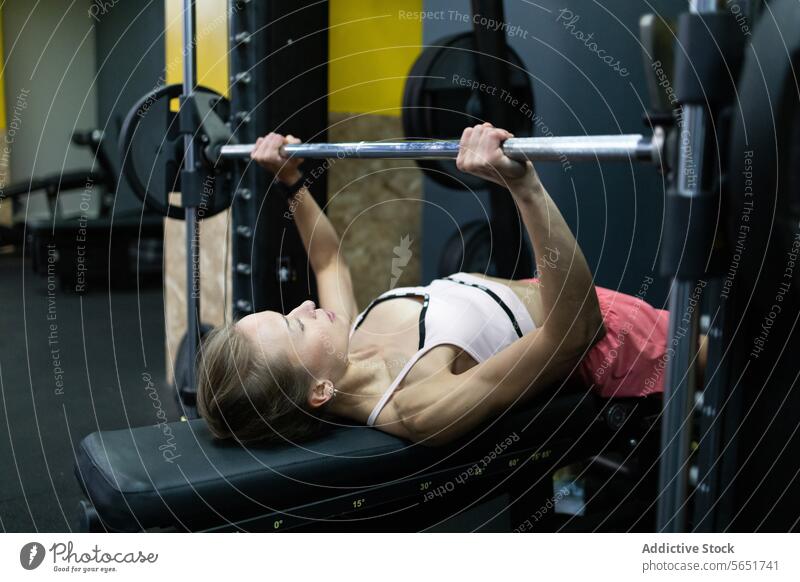 Fitnessbegeisterte Frau übt Bankdrücken im Fitnessstudio Training Übung Curl-Hantel Heben Gesundheit Sport Stärke Athlet Fokus Tatkraft Gerät im Innenbereich