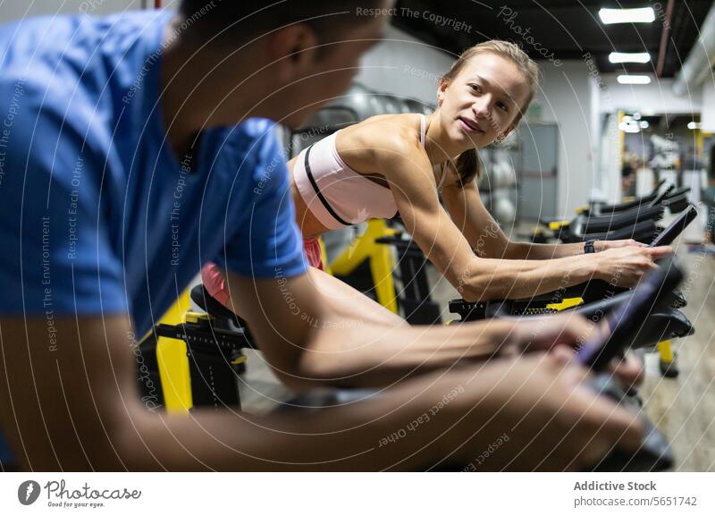 Fitnessbegeisterte nutzen stationäre Fahrräder im Fitnessstudio Fahrrad Spinning ruhend Training Übung aktiv Lifestyle im Innenbereich Zentrum Sport Gesundheit