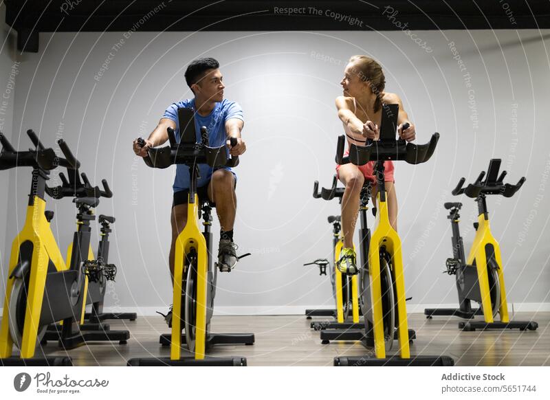 Indoor-Cycling-Session mit konzentrierten Teilnehmern im Innenbereich Fahrradfahren Fitness Fitnessstudio Training stationäres Fahrrad Übung Sport Gesundheit