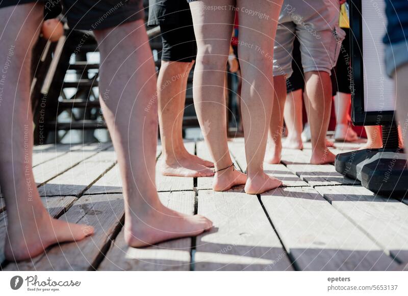 Beine von Menschen die am Nordseestrand vor einer Pommesbude in der Schlange stehen warten Warteschlange Holzsteg Ferien & Urlaub & Reisen Steg Erholung Sommer