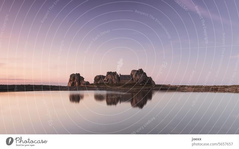 Einsames Haus am Wasser zwischen riesigen Felsen Sehenwürdigkeit Meer Tag Einfamilienhaus solide ruhig Frankreich maritim Farbfoto Menschenleer Spiegelung braun