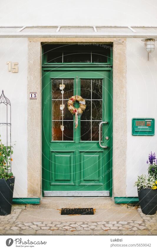 Foto einer klassischen grünen Holzeingangstür zu einem Gebäude an einem sonnigen Tag ohne Menschen Holztür alt Eingang Eingangstür türkis Eingangstor Ausgang
