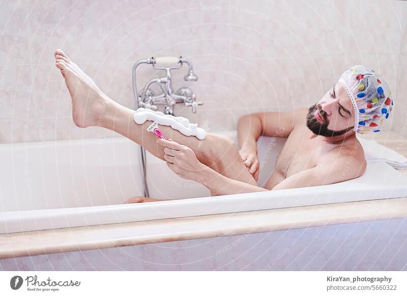 Bärtiger Mann mit Duschhaube entspannt sich bei der Rasur im Bad. Haut- und Selbstpflegekonzept, Männergesundheit ist wichtig Selbstfürsorge Vollbart Hygiene