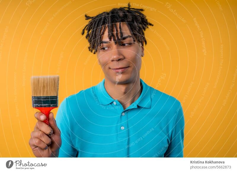 Kreative Mann Künstler mit Malerei mit Pinsel auf gelbem Hintergrund. Fantasie, Idee abstrakt Erwachsener Afrikanisch Amerikaner Kunst künstlerisch Kunstwerk