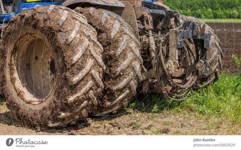 schmutzige Doppelräder eines landwirtschaftlichen Traktors auf einem unbefestigten Weg an einem sonnigen Sommertag dreckig verdoppeln Wagenräder Ackerbau