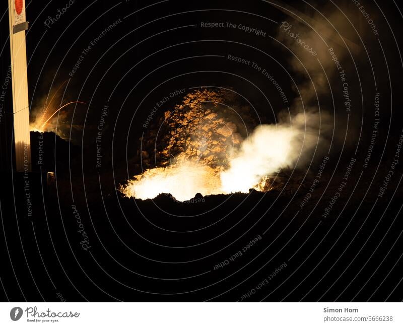 Löcher in der Erde, die qualmen, rauchen und brennen Explosion Qualm Rauch Feuer Funken Energie heiß Nacht Pyrotechnik Feuerwerk Effekte Licht