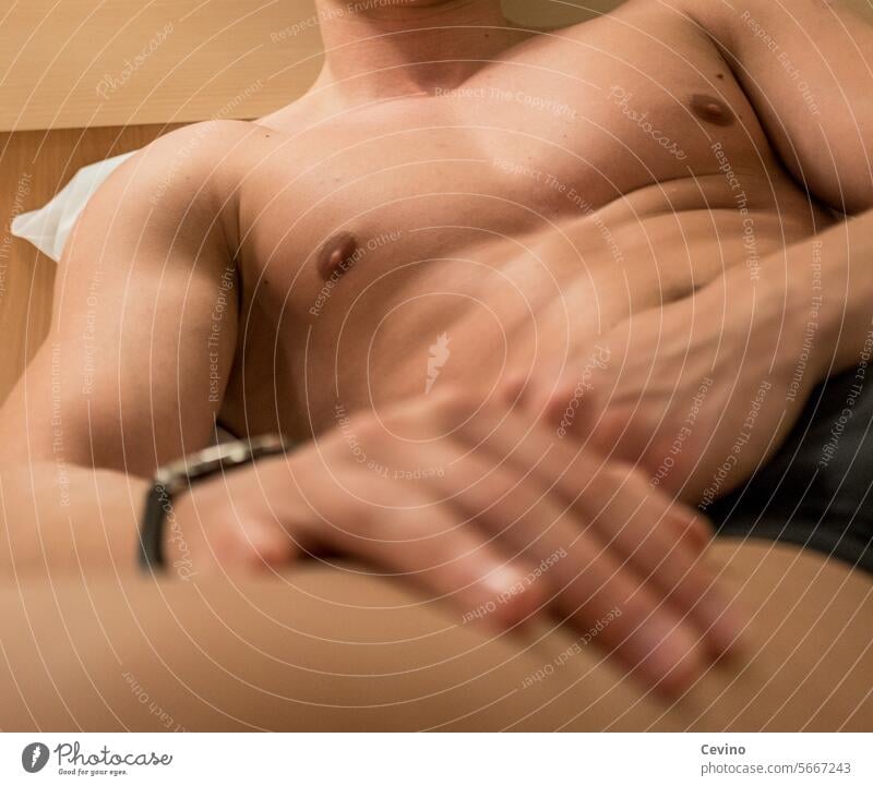 Muskulöser Mann mit freiem Oberkörper liegt in einem Bett Muskeln Sixpack Sexy erotisch Erotik freier Oberkörper trainiert muskulös muskulöse männliche Brust