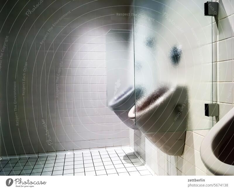 Toilette toilette klo wc sanitärtrakt pissoir pinkeln pinkelbecken klobecken spülung kacheln fliesen weiß glas scheibe trennung abtrennung sichtschutz