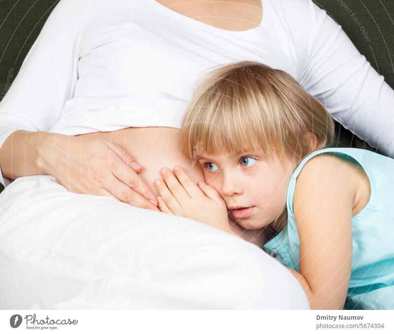 Schwangere Frau mit Tochter anhänglich Vorfreude ängstlich wartet auf Babys Bauch Bruder Pflege Kaukasier Kind Kindheit Embryo Erwartung erwartend Familie