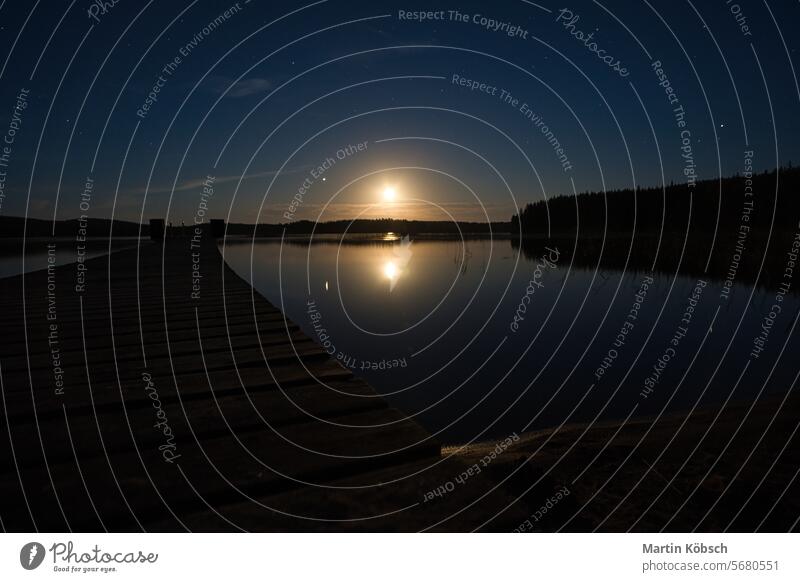 Sonnenuntergang an einem See in Schweden. Das Mondlicht spiegelt sich in dem ruhigen Wasser. Reflexion & Spiegelung kleinund reisen Leichtigkeit Natur Wald