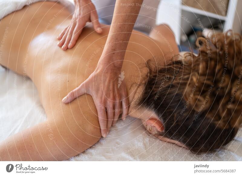 Crop-Masseurin knetet den Rücken eines Kunden im Krankenhauszimmer Frauen Osteopath geduldig Ernennung Massage Schulter Sitzung manuelle Therapie Erwachsener