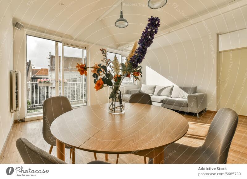 Modernes Wohnzimmer mit Balkonblick und Tageslicht Innenbereich Sofa Esstisch natürliches Licht bequem gemütlich modern Wohnkultur Appartement Möbel Stock Holz